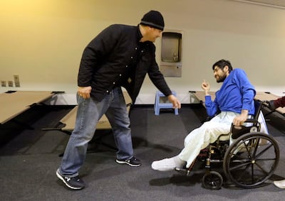 Jesse Kinman welcomes Ivan Esparza to the Puyallup Nazarene Church as Esparza picks out a cot to sleep on, as part of Freezing Nights, in Puyallup, Wash., on Sunday, Jan. 26, 2020. Kinman helps volunteer with Freezing Nights and is also homeless himself. Kinman sleeps in his van outside of Walmart.