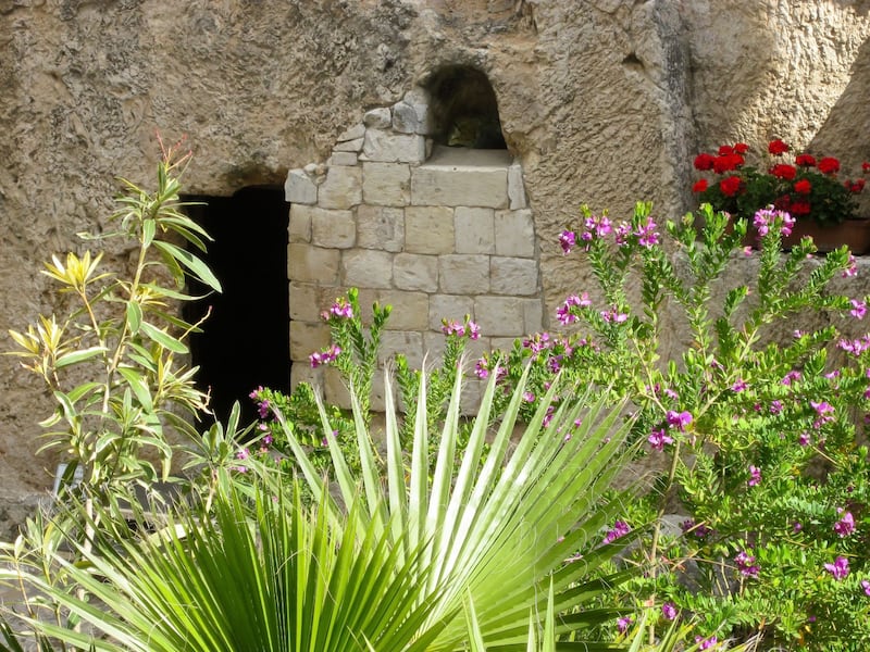 The entrance to the Garden Tomb amid native plants and flowers.
