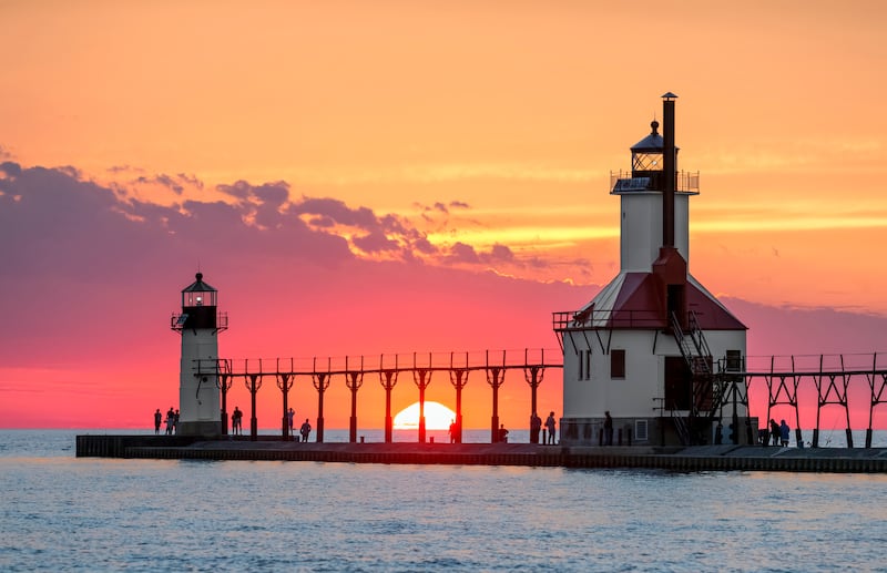 On the summer solstice, the sun sets on Lake Michigan between the Inner and Outer North Pier Lighthouses at St. Joseph, Michigan.