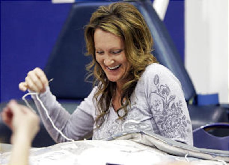 Laura Lindsey, Murray, works on a quilt during the BYU Women's Conference evening of service in Prov