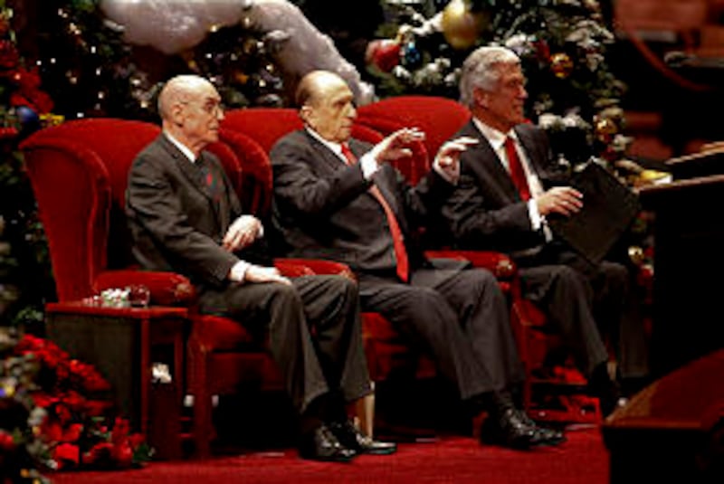 President Thomas S. Monson, center, gestures for the audience to sit down prior to the First Preside