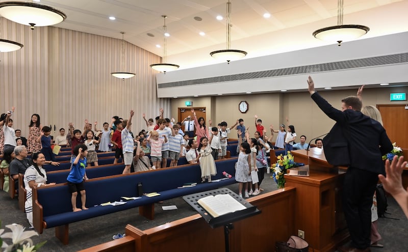 During his ministry to Singapore, Young Men General President Timothy L. Farnes invited children to stand up, raise their hands and commit to reading the scriptures daily.