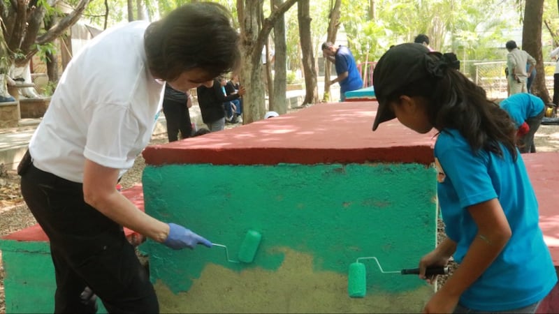 President Susan H. Porter helps a girl paint portions of a public park during a service activity in Tuxtla Gutiérrez, Chiapas, Mexico, in May 2026.