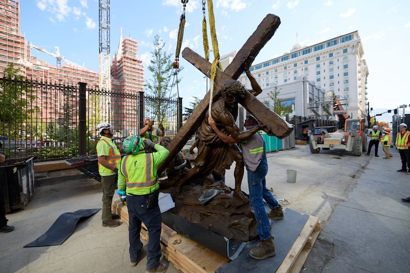 Crew members install the “Jesus Christ Carrying the Cross” statue, created by Michael Hall, just south of the Salt Lake Temple on Wednesday, Sept. 17, 2025.