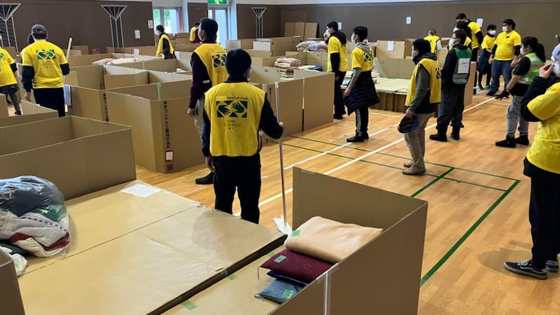 Around 20 volunteers wearing yellow Helping Hands vests sweap and clean an evacuation center for earthquake evacuees n Nanao, Japan.