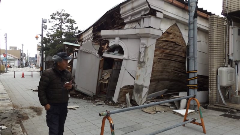 A man walks past a traditional building in Nanao, Japan, that suffered severe damage from the Noto Peninsula earthquake.