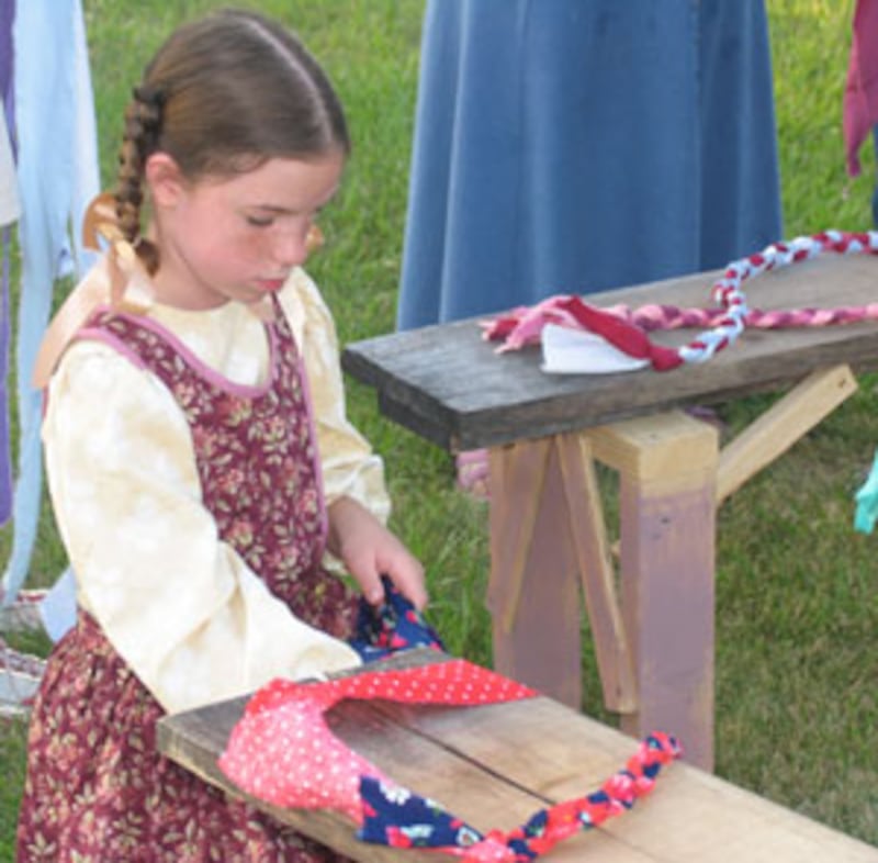 Emily Pipe learns rug braiding in pre-show activity in connection with new Nauvoo Pageant.