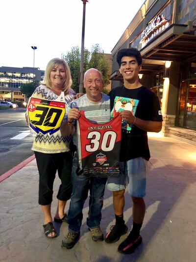 Right, Rene “R.J.” Rodriguez presents Steve and RaKell Syddall with items he wore representing their late son Hunter Syddall at the motocross national championships last week.