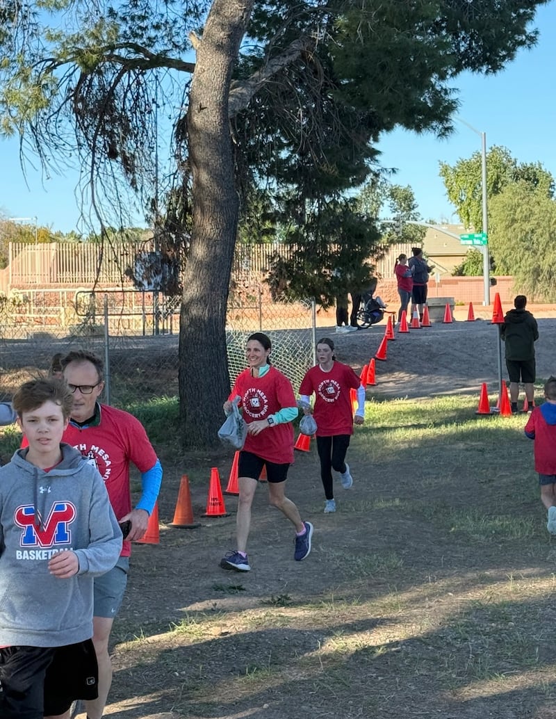 Participants run to the finish line with grocery bags full of donated food during the second annual Northeast Mesa Grocery Run in Mesa, Arizona, on Feb. 21, 2026.