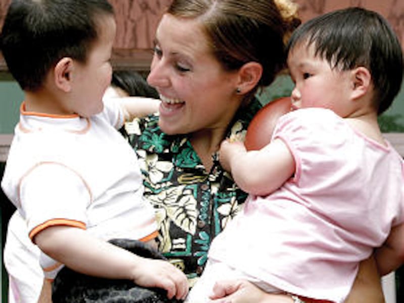 Gina Smith, who has since graduated, holds two babies during the BYU-Hawaii Concert Choir visit to a