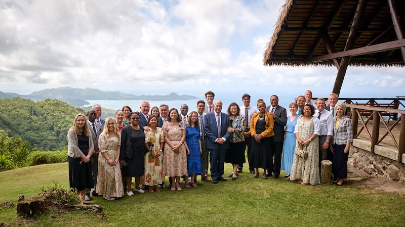 A group stands with Elder Ronald A. Rasband of the Quorum of the Twelve Apostles, center, in Seychelles on Oct. 28, 2025.