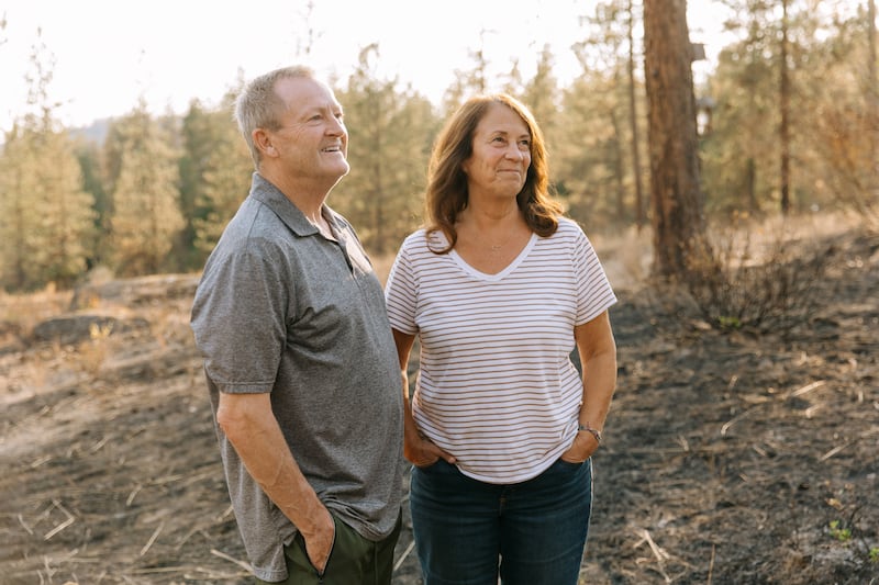Standing in the ashes not far from their home, Todd and Debbie Rogers tell the story of how their house survived the Spokane wildfires in Spokane, Washington, on Saturday, Aug. 22, 2026.