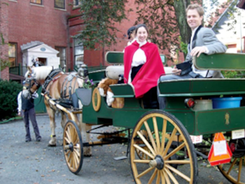 Nicole Benvie, portraying Vilate Young, and Fred Brown, portraying Brigham Young, arrive in horse-dr