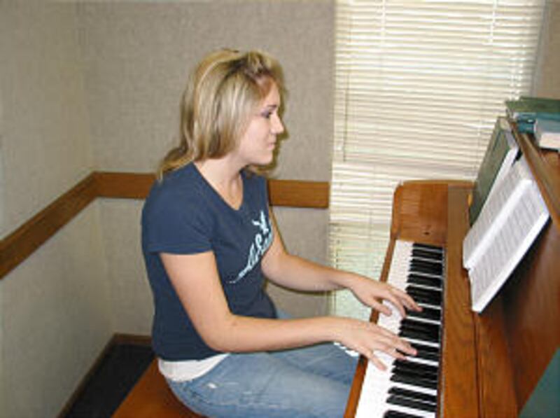 Hannah Hinrichsen plays piano for institute class devotional.