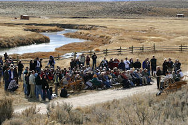 People gather on bank of the Sweetwater River for unveiling of statues honoring pioneer heroes.