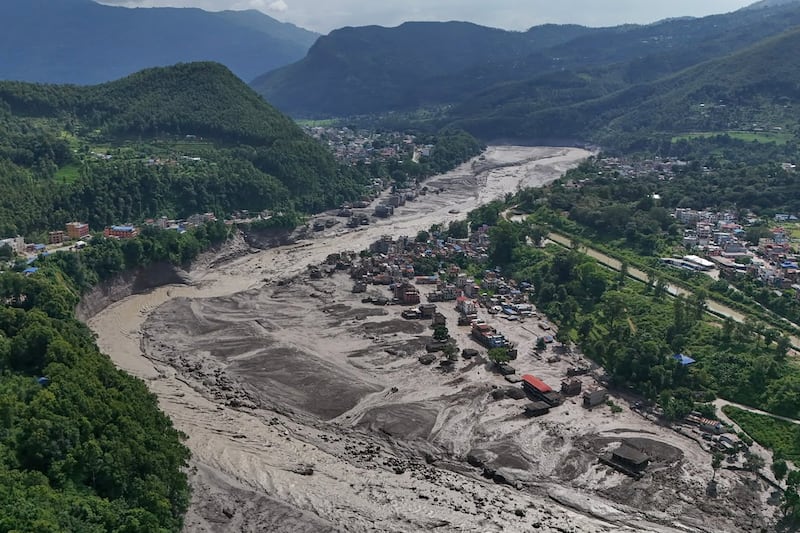 Damaged houses stand precariously near the swollen, debris-choked banks of the Trishuli River after flash floods in Nepal's Nuwakot district on Wednesday, Aug. 26, 2026.