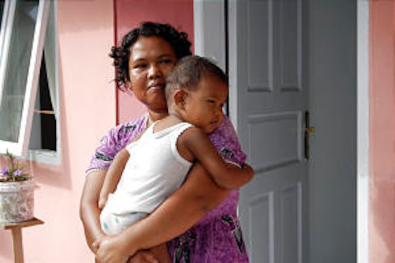 Church humanitarian projects in Indonesia following 2004 tsunami. Young mother, Woman holds child at