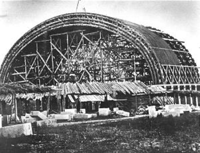 Lattice-work roof support can be seen in photo of building under construction.