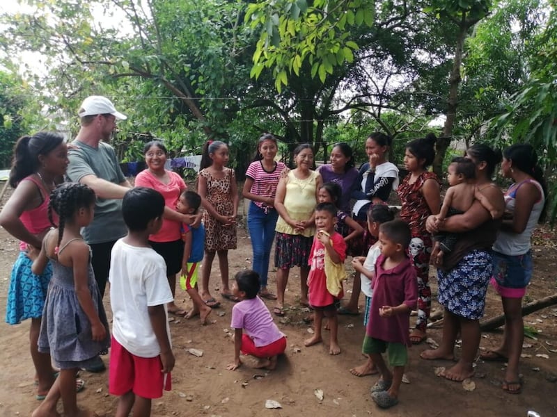 Kenneth Grover, left, meets with community members in one of the areas where he sponsors scholarships for primary school-aged children in Guatemala.