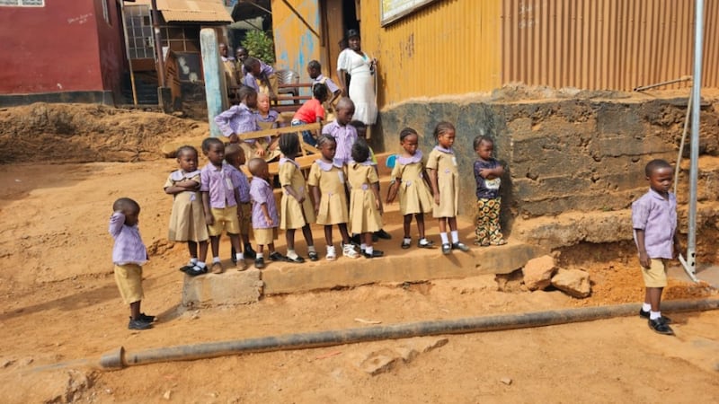 School children watch the donation of a water well at New England Ville in Freetown, western Sierra Leone on April 3, 2026.