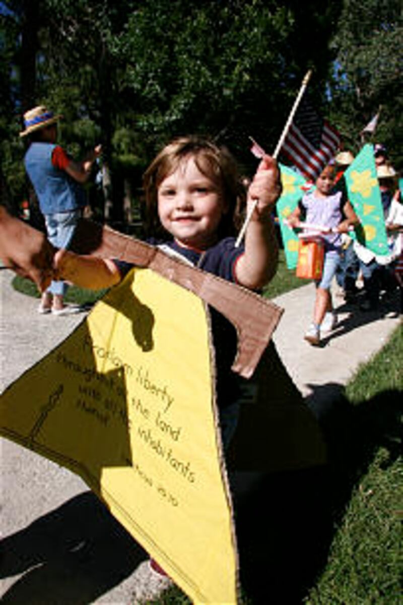 Patriotic youngster waves Old Glory during the annual children's parade. The Primary children donned