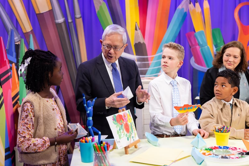 Elder Gerrit W. Gong and Sister Susan Gong make a Noah's ark craft with children during the filming of a Friend to Friend video available on Sunday, May 24, 2026.