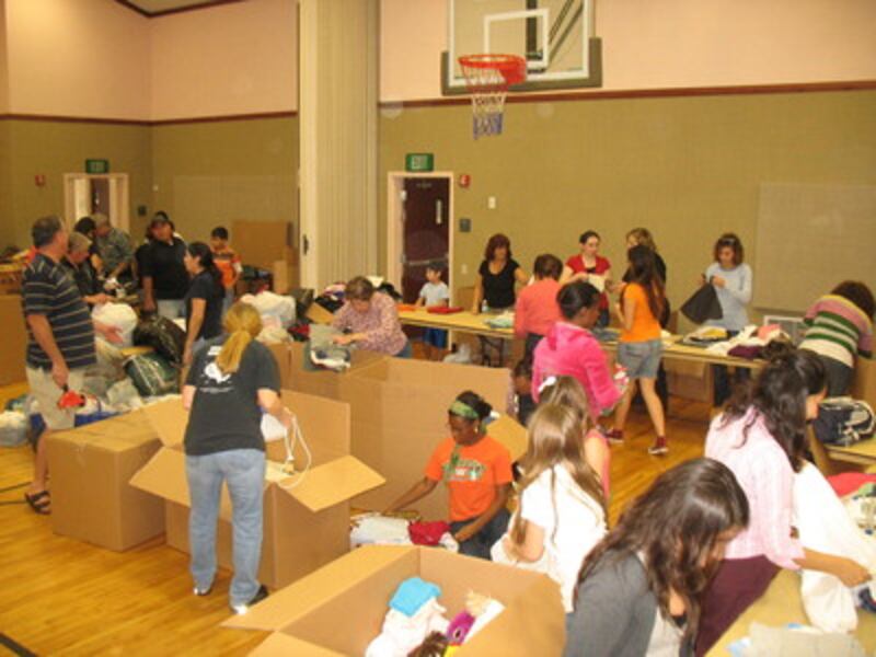 Volunteers sort and box donations.