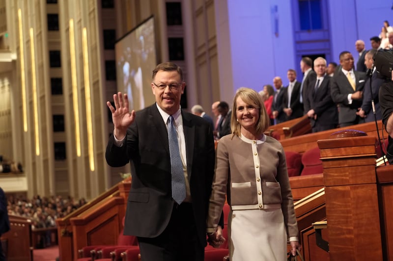 Elder Clark G. Gilbert, of the Quorum of the Twelve Apostles, waves as he and his wife, Sister Christine Gilbert, exit at the end of the Saturday afternoon session of the 196th Annual General Conference of The Church of Jesus Christ of Latter-day Saints, held at the Conference Center in Salt Lake City on Saturday, April 4, 2026.