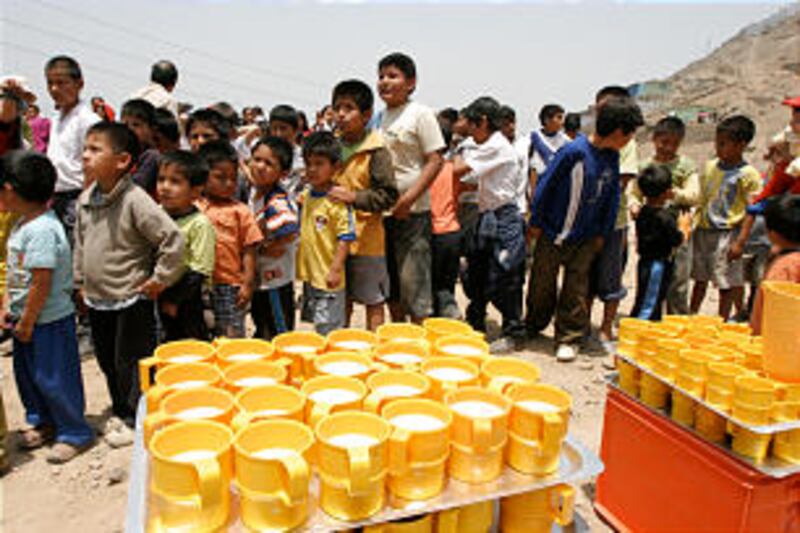 Dozens of boys form an orderly line as they await a hot breakfast of apple oatmeal and bread. A soli