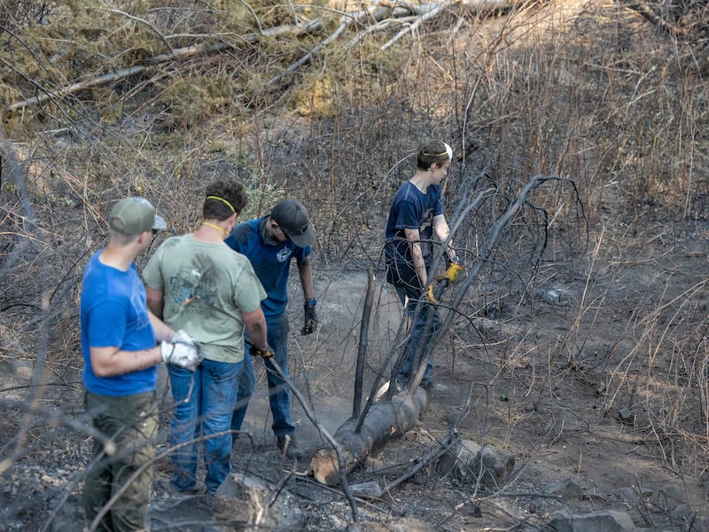 Young men and leaders from the Spokane Washington Mount Spokane Stake help clear debris from a neighborhood damaged by wildfires in Spokane, Washington, on Monday, Aug. 3, 2026.