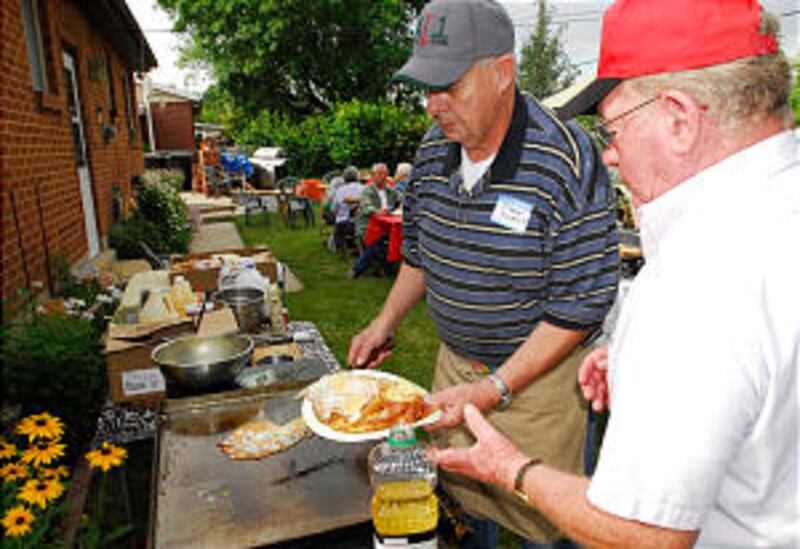 Members of the Bountiful 15th Ward prepare food during a neighborhood breakfast. Neighbors and frien