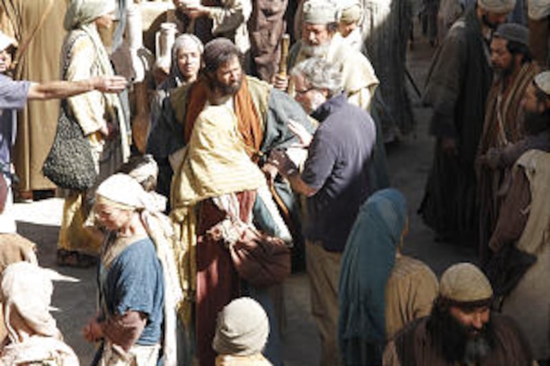 A member of the production staff works with an actor at a marketplace scene during the final week of