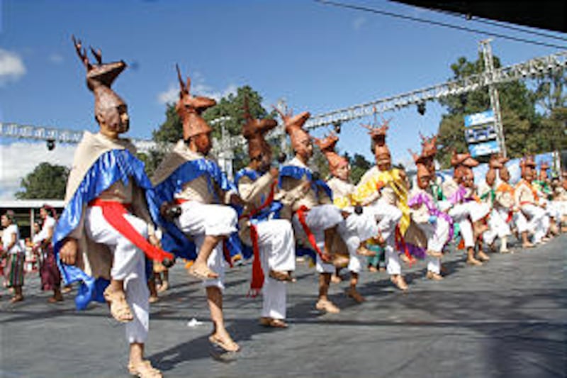 A line of young men don decorative deer headdresses while performing a folk dance during the Dec. 10