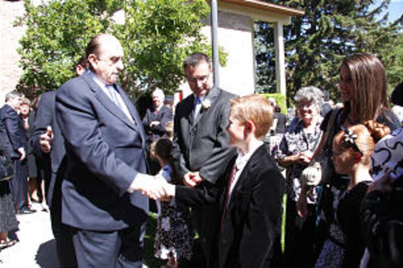 President Thomas S. Monson shakes hand of Keenan Faulkner, 9, a great-grandson of Barbara B. Smith a