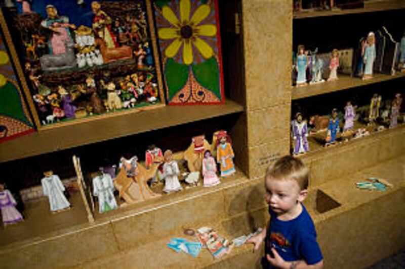 Young Justin Christensen plays with some puppets at one of the interactive stations at a new childre