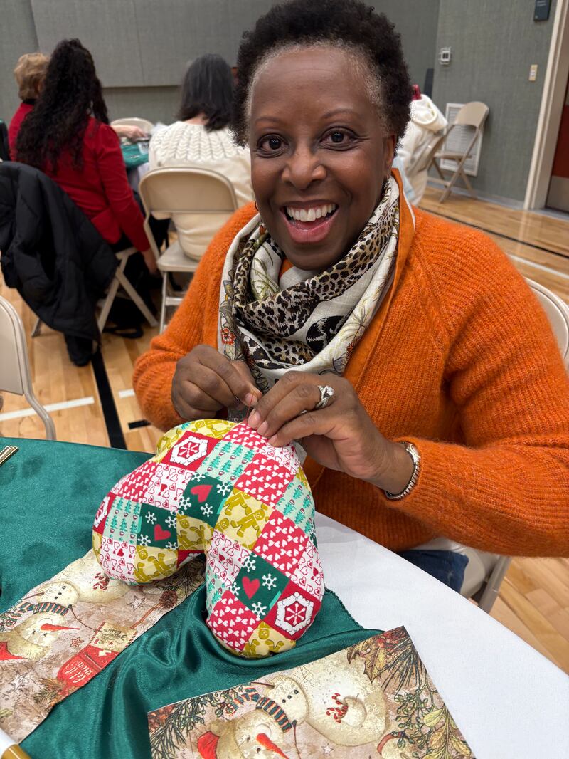 A member of the Round Rock Texas Stake stuffs and stitches a heart-shaped pillow for children recovering from cardiovascular surgery during the annual Silver Belles luncheon in Cedar Park, Texas, Dec. 3, 2025.