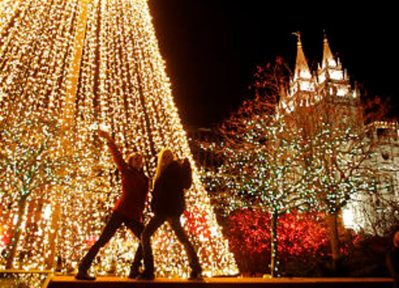 Alexis Kirby and Bobbie Carroll pose for a family photo on the Main Street Plaza as Christmas ligh