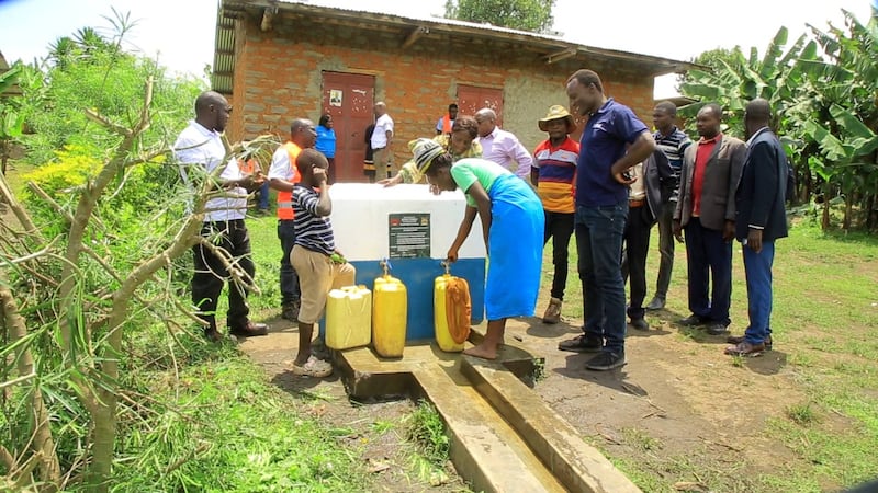Leaders and community members use a newly constructed water point in Kabarole District, Uganda, on Sept. 30, 2025.