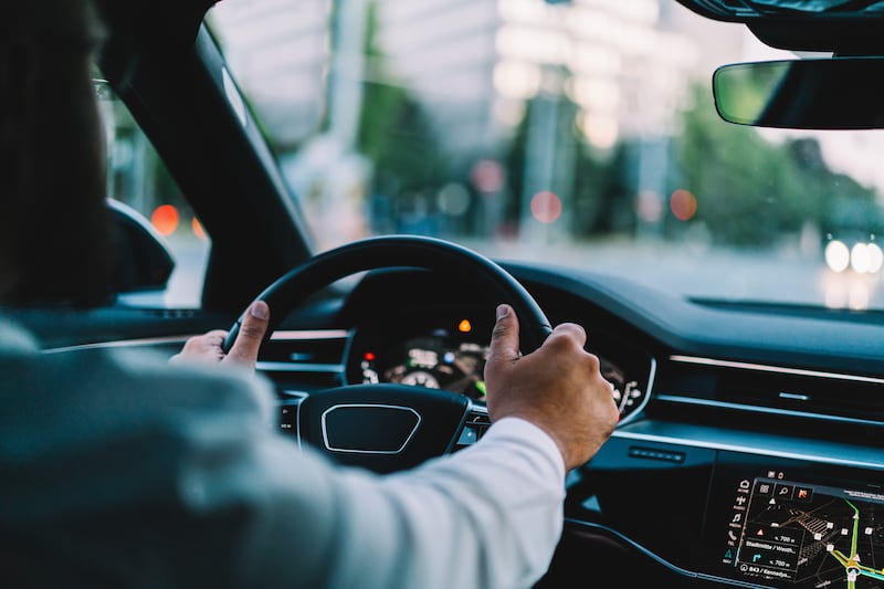 View from the backseat of a person driving in a city.
