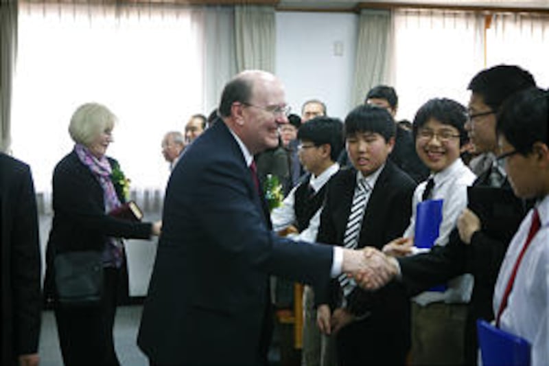 Elder Quentin L. Cook greets a member of the Cheongju Korea Stake youth choir.