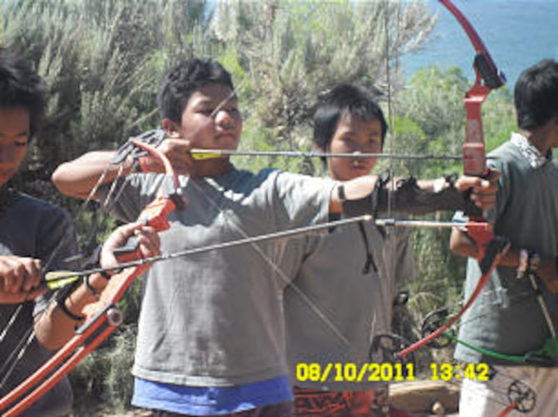 Young refugee Boy Scouts sharpen their archery skills at Scout camp. Scouting has provided the young