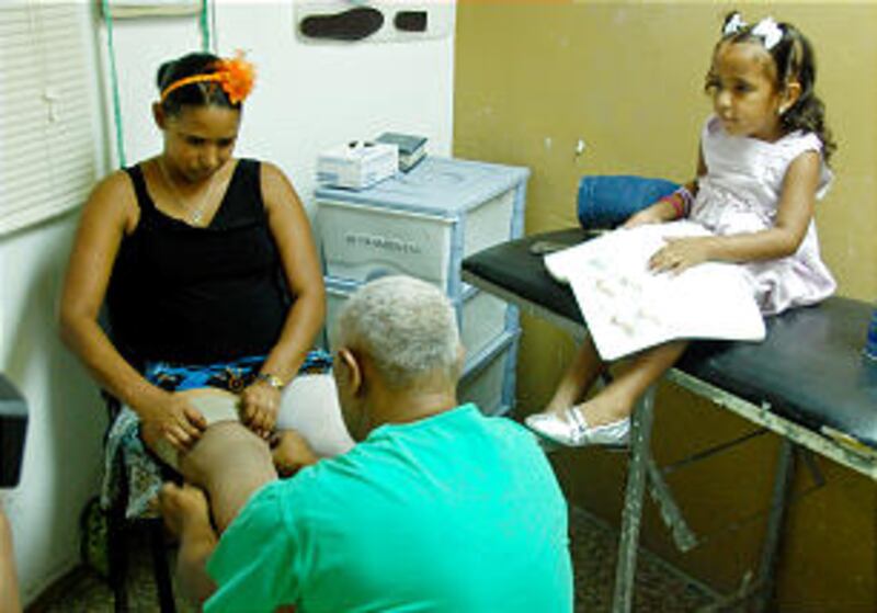 Mayerlinth Reyes is fitted with two prosthetic legs while her daughter watches. Her new mobility wil