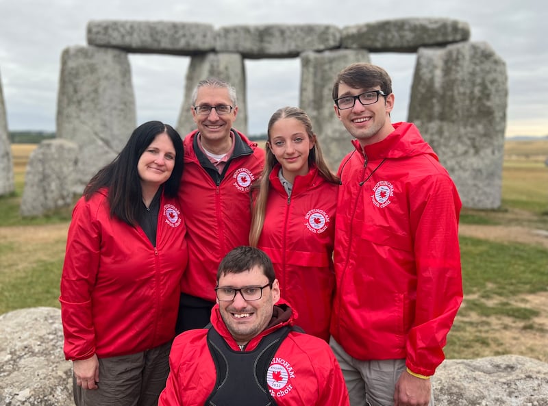 Elder Nathan Smith, front center, smiles with his family in front of the Stonehenge landmark in England on August 9, 2025.