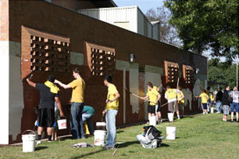 Members of the Inglewood California Stake paint the gym at Enterprise Park in South Central Los Ange