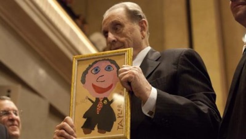 President Thomas S. Monson has a present given to him by a member of the audience. The picture is th