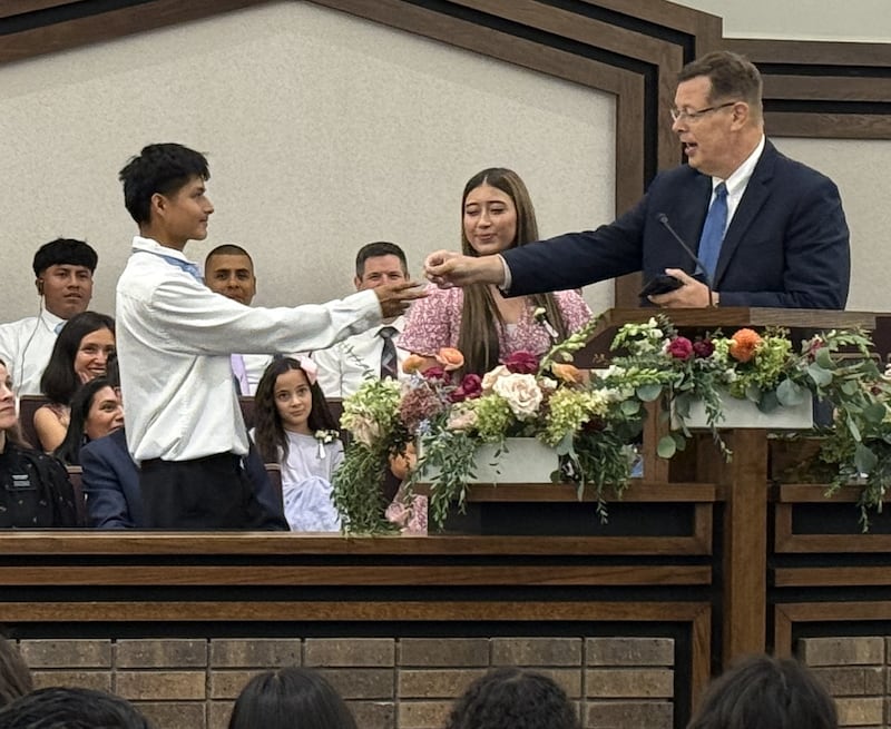 Elder Clark G. Gilbert of the Quorum of the Twelve Apostles hands Jose Coy, 18, a card with his email address on it at the Schaumburg Illinois Stake Center in Chicago, Illinois on Sunday, Sept. 20, 2026.