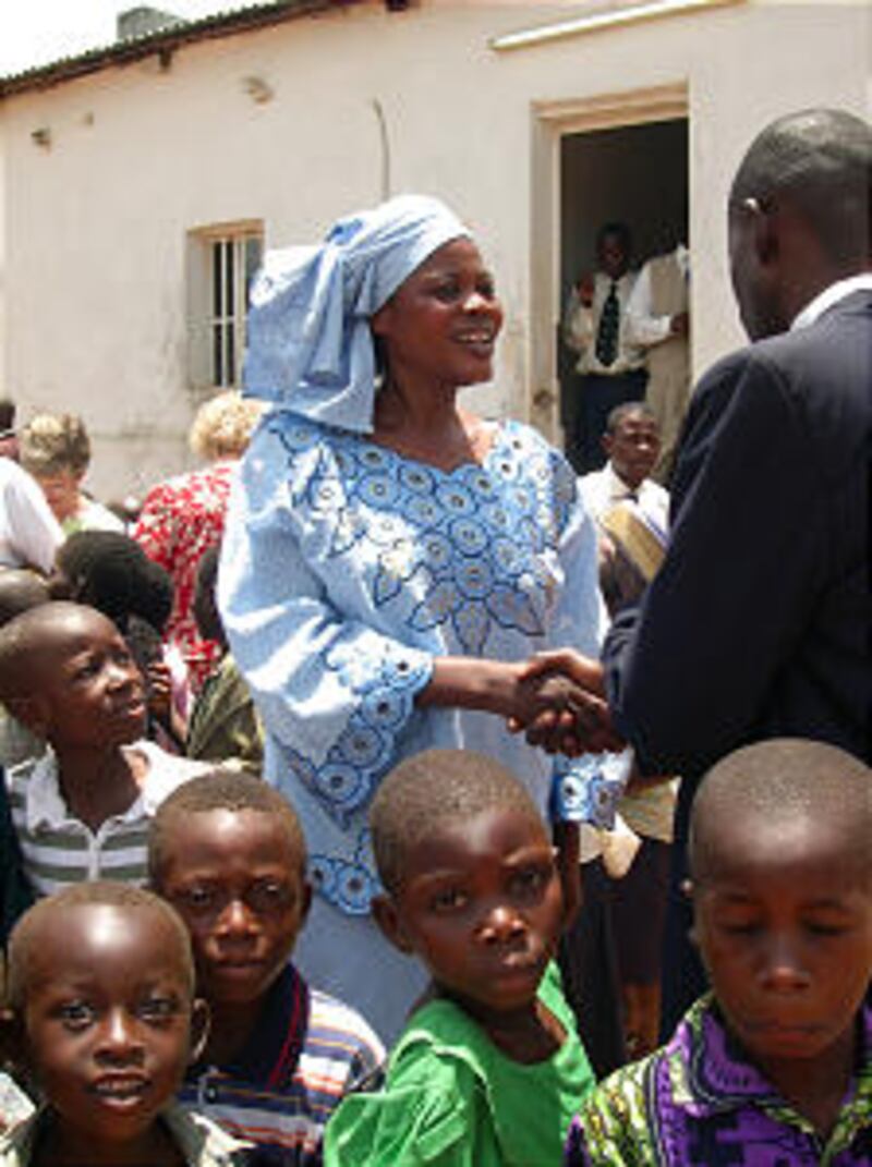 Maree Jose, a doctor and member of the water committee, greets local Church leader in Luputa.
