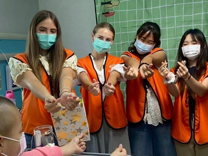 Latter-day Saint young adults share heart sign gestures with a young cancer patient at a children’s hospital in Changhua City, Taiwan. The young adults visit the hospital twice a month to share music and art therapy classes.