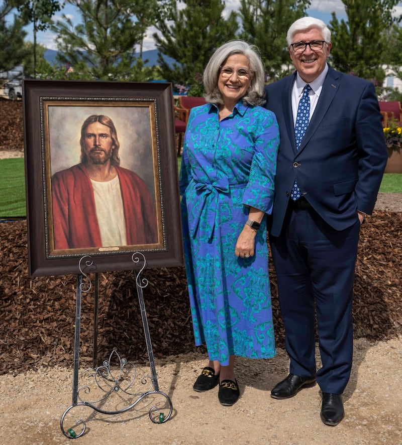 Elder José A. Teixeira, a General Authority Seventy and president of the United States Central Area, and his wife, Sister Maria Teixeira, pause for a photo by a painting of the Savior at the Missoula Montana Temple groundbreaking ceremony.