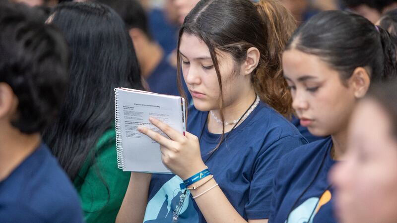 A young woman takes notes during a session of For the Strength of Youth conferences across the South America South Area in early 2026.